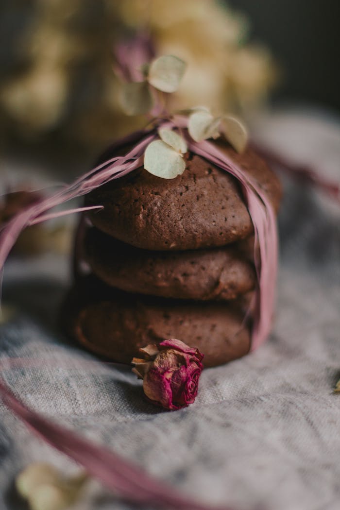 Stacked chocolate cookies tied with pink ribbon, showcasing rustic, indulgent charm.