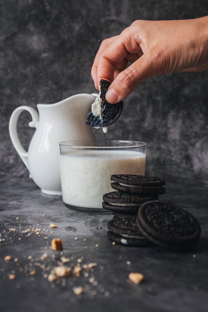 A delicious snack of chocolate cookies being dipped in milk, perfect for indulgence.